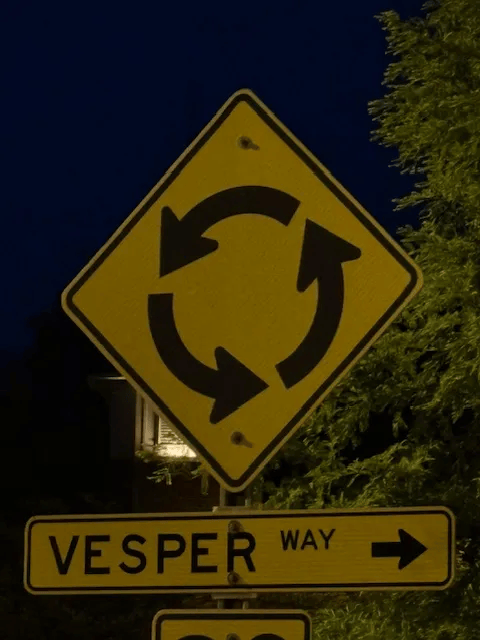 This is a photo of a traffic sign pointing towards a street named Vesper Way.  